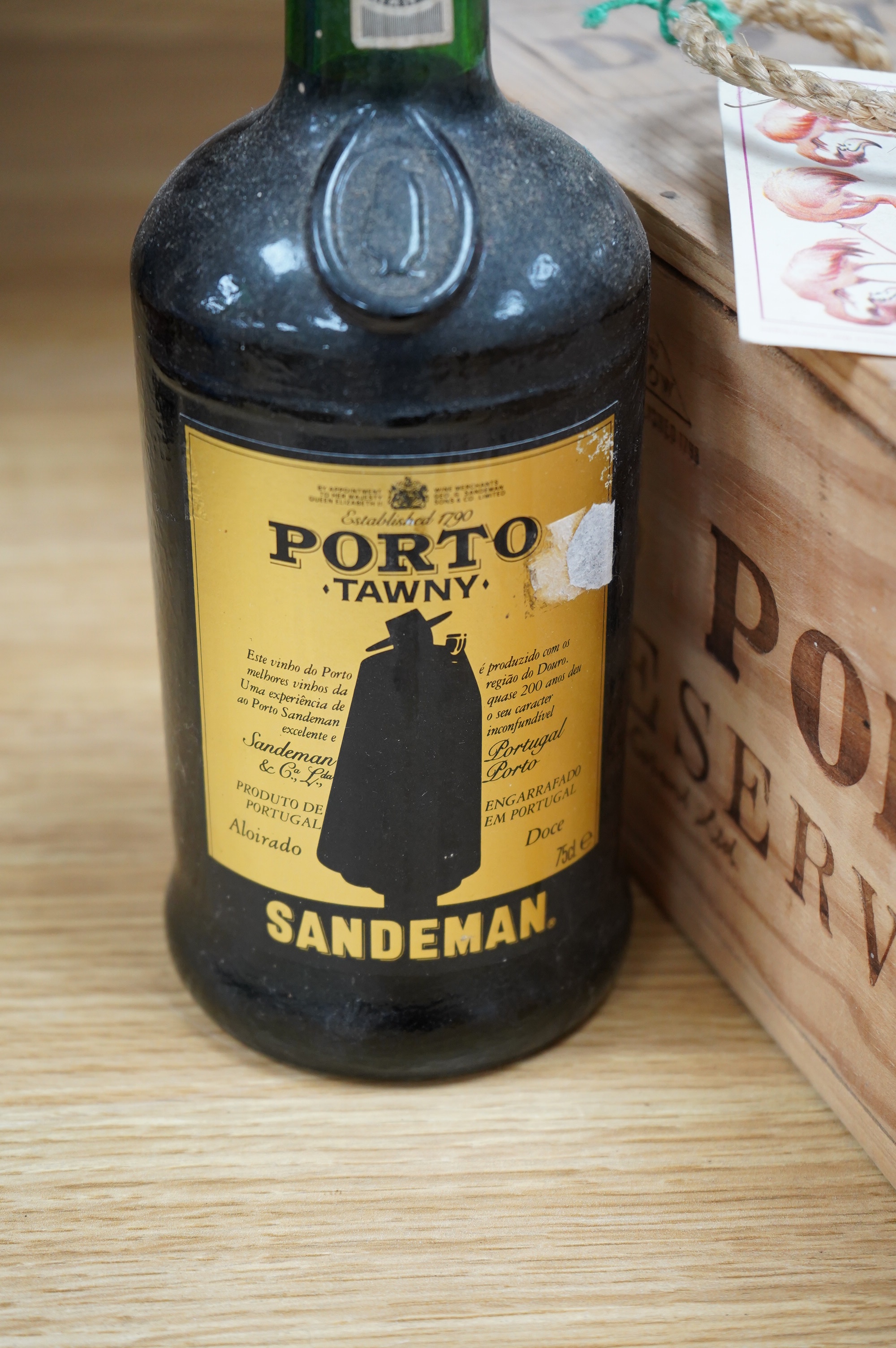 One wooden box of unopened Dow’s Port Reserve 1974, together with a bottle of Sandeman Tawny Port. Condition - storage unknown